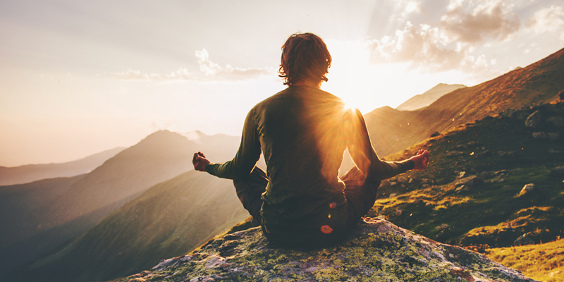 A man meditating on a mountaintop